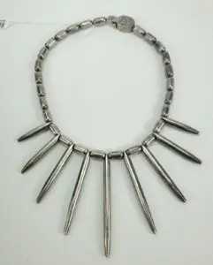 Metallic spiked necklace on white background.
