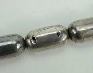 Silver metal oval beads close-up.