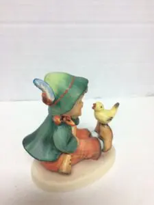 Child figurine with a bird statue.