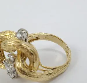 Gold ring with intricate design and diamonds.