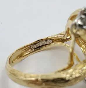 Gold ring with engraved hallmark inside band.