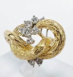 Gold knot brooch with diamond accents.