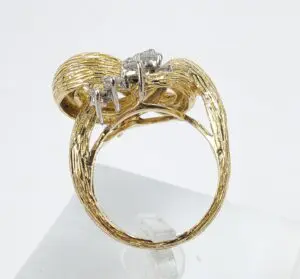 Gold ring with intricate design and diamond.
