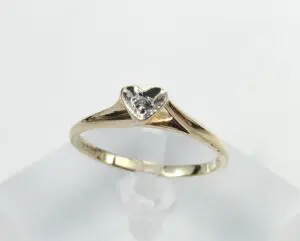 Gold ring with heart-shaped diamond setting.