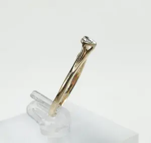 Gold ring with a clear gemstone displayed.