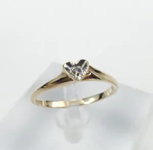 Gold ring with heart-shaped diamond centerpiece.