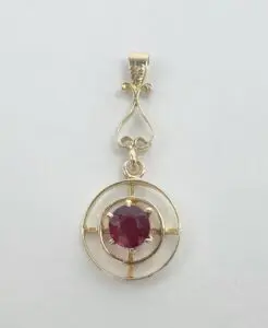 Gold pendant with a red gemstone.