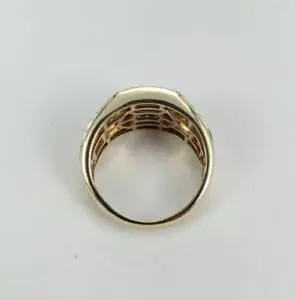 Gold ring with intricate design, side view.