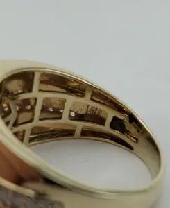 Gold ring with engraved markings inside band.