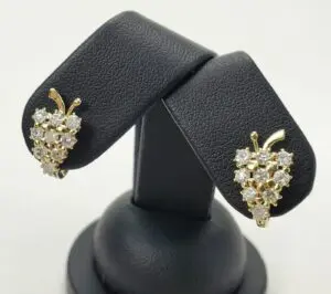 Gold and diamond grape-shaped earrings display.