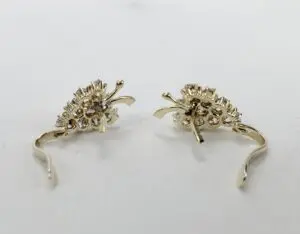 Gold decorative earrings on white background.