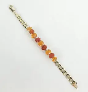 Gold bracelet with orange gemstone beads.