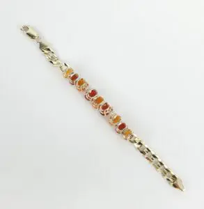 Gold bracelet with orange gemstones on display.