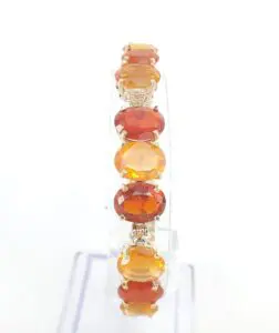 Orange gemstone bracelet on a clear stand.