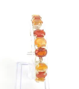 Orange gemstone bracelet on clear stand.