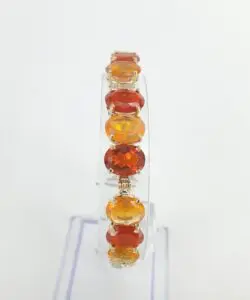 Orange gemstone bracelet on clear display stand.