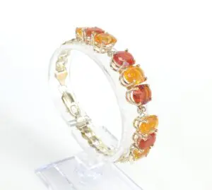 Gold bracelet with orange gemstones display.