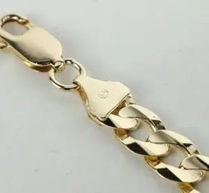 Close-up of gold chain bracelet clasp.