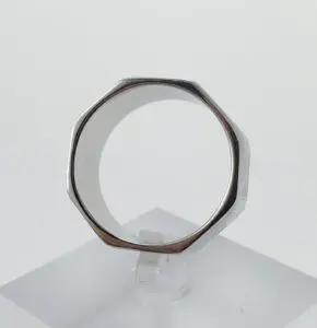 Octagonal silver ring on clear stand.