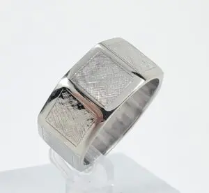 Silver ring with textured square design.