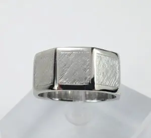 Silver ring with textured square design.