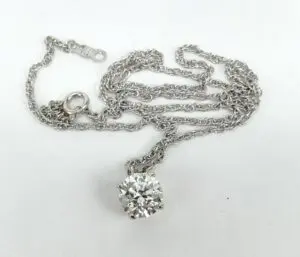 Silver necklace with a round diamond pendant.