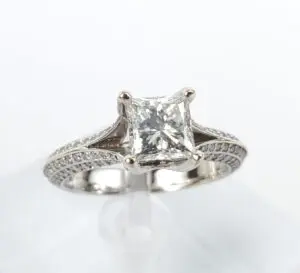 Princess-cut diamond engagement ring on stand.