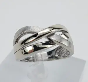 Silver intertwined band ring on display stand.