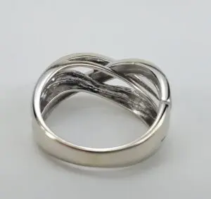 Silver intertwined band ring on white background.