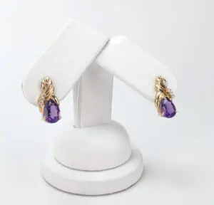 Gold earrings with purple gemstones displayed.