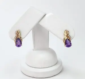 Gold earrings with purple gemstones displayed.