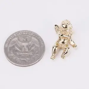 Gold angel charm next to a quarter.