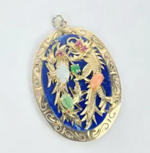 Gold pendant with colorful gemstones and design.