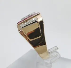 Gold ring with diamond accents on stand.