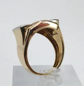 Gold ring with geometric design on stand.