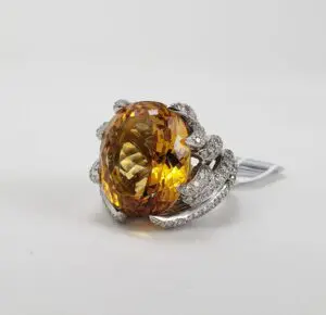 Yellow gemstone ring with intricate silver setting.