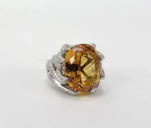 Golden gemstone ring with silver detailing.