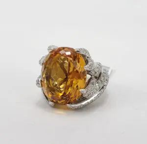 Golden gemstone ring with silver detailing.