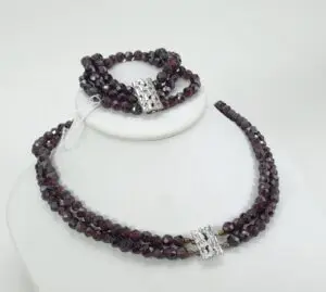 Dark beaded necklace and bracelet on display.