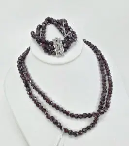 Dark beaded necklace and bracelet on display.