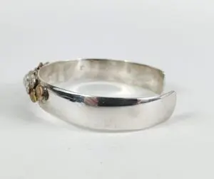 Silver cuff bracelet with decorative accents.