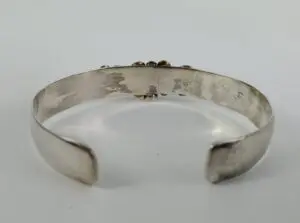 Silver cuff bracelet with textured surface.