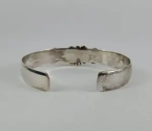 Silver cuff bracelet on white background.