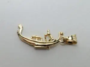 Gold boat pendant with two figures.