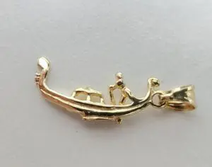 Gold lizard-shaped pendant on white background.