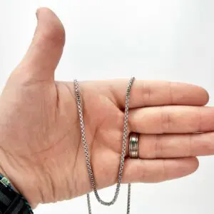 Hand holding silver chain with rings.