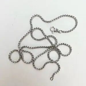 Silver chain with lobster clasp on white background.