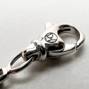 Silver clasp with engraved logo detail.