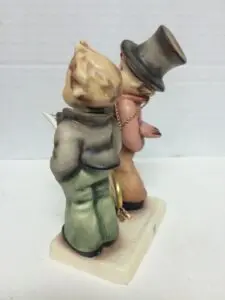 Two figurines in vintage clothing, standing.