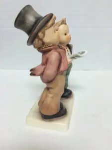 Two figurines, one holding a newspaper.